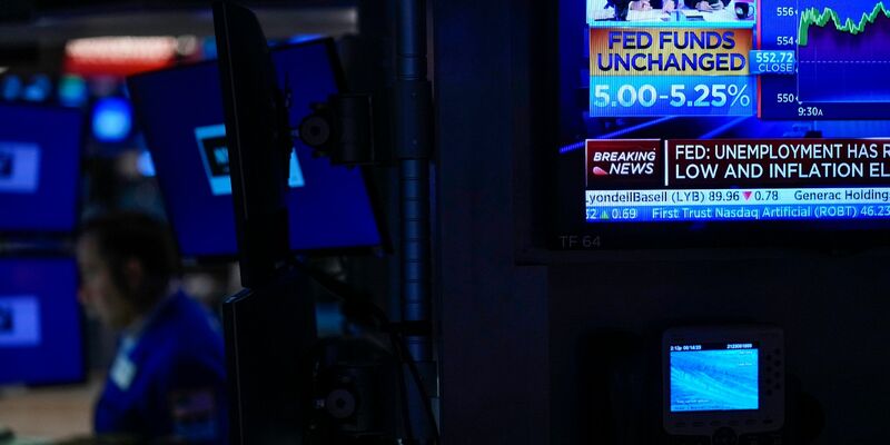 Ein Fernseher zeigt Nachrichten zur Federal Reserve (Fed). (Archivbild) - Foto: Seth Wenig/AP/dpa