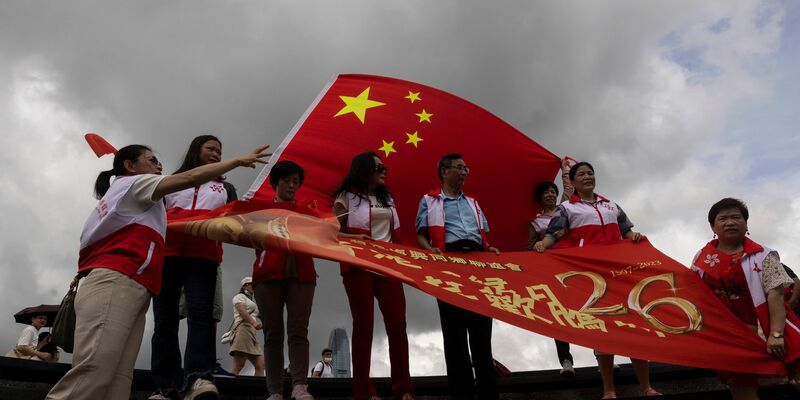 Peking-Befürworter halten chinesische Fahnen anlässlich des 26. Jahrestages der Übergabe der Kontrolle über Hongkong von Großbritannien an China. Führende EU-Vertreter erheben mit einem neuen Bericht zu den Entwicklungen in Hongkong schwere Vorwürfe gegen die politische Führung in Peking. - Foto: Louise Delmotte/AP/dpa