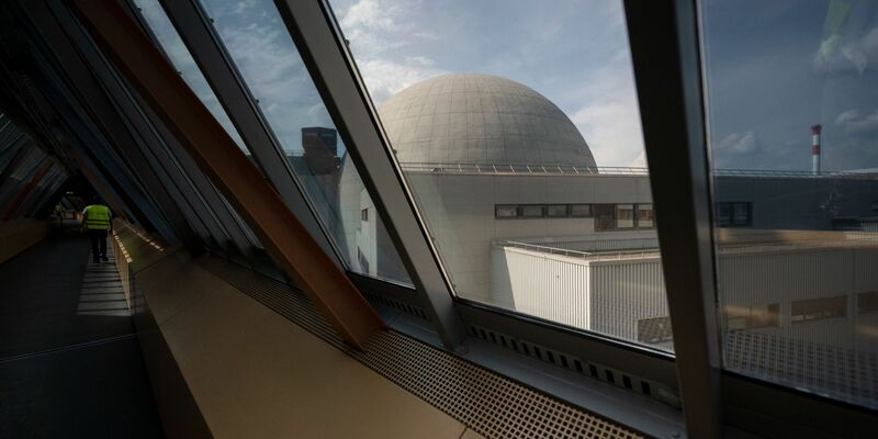 Ein Mann geht während eines Presserundgangs einen oberirdischen Gang auf dem Gelände des Atomkraftwerks Neckarwestheim entlang. - Foto: Marijan Murat/dpa