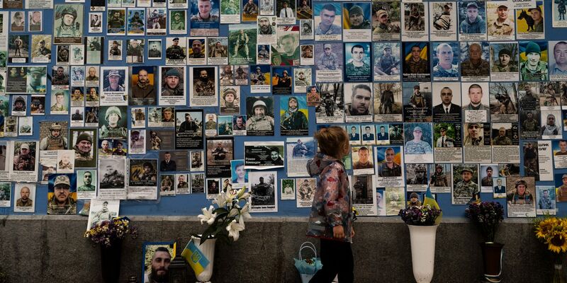 Ein Mädchen betrachtet Fotos von ukrainischen Soldaten, die im Krieg gegen Russland gefallen sind. - Foto: Jae C. Hong/AP/dpa