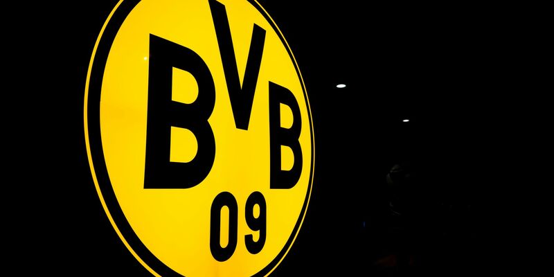 Das Logo des BVB leuchtet in der Dunkelheit. - Foto: David Inderlied/dpa