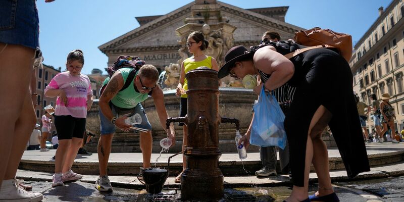 Menschen kühlen sich an einem Springbrunnen vor dem Pantheon in Rom ab. - Foto: Andrew Medichini/AP/dpa