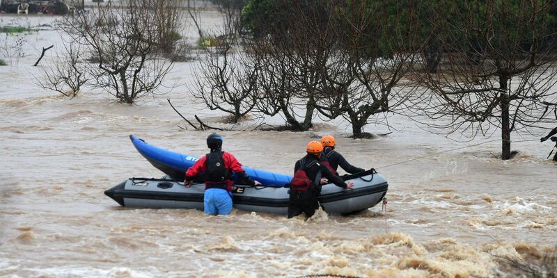 Helfer bereiten sich mit einem Schlauchboot auf die Rettung von Opfern einer Unwetterfront in Chile vor. - Foto: Alex Betran/Agencia Uno/dpa