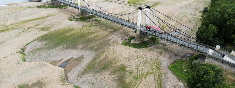 Dieses Luftbild zeigt eine Brücke über das ausgetrocknete Flussbett der Loire in Westfrankreich. - Foto: Damien Meyer/AFP/dpa