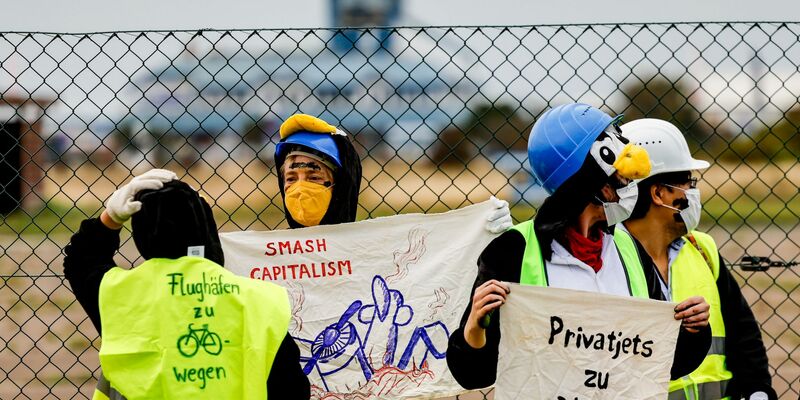 Die Aktivistin werden von Polizisten überprüft. - Foto: Axel Heimken/dpa