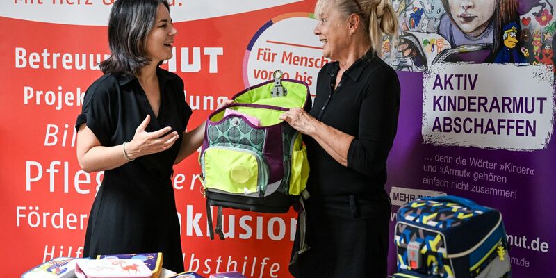 Außenministerin Annalena Baerbock (l, Bündnis 90/Die Grünen) und Angela Schweers, Vorstandvorsitzende AWO Potsdam, übergeben gesammelte Schulranzen an Kinder. - Foto: Jens Kalaene/dpa