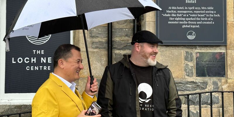 Paul Nixon (l) vom Loch Ness Centre und der Projektleiter Alan McKenna neben der Plakette, die an eine berühmte Nessie-Sichtung im Jahr 1933 erinnert. - Foto: Benedikt von Imhoff/dpa