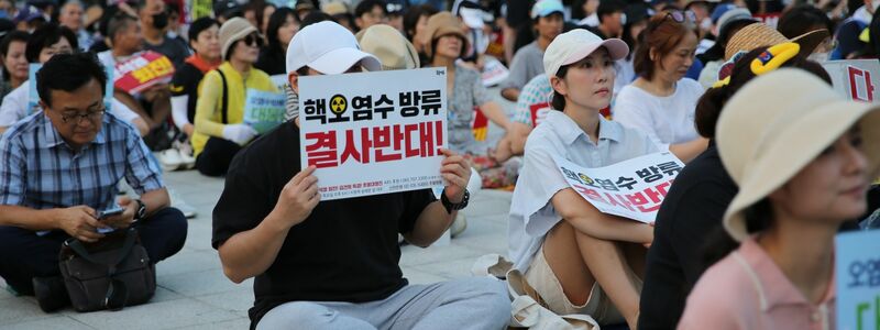 Auch im südkoreanischen Busan demonstrieren Menschen gegen die begonnene Einleitung aufbereiteten Kühlwassers aus der Atomruine Fukushima ins Meer. - Foto: Lu Rui/XinHua/dpa