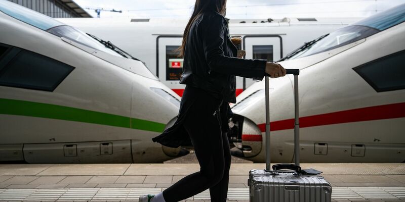 Eine Reisende geht am Hauptbahnhof in München an ICE-Zügen vorbei. - Foto: Lennart Preiss/dpa