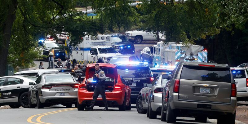 Polizei und Ersthelfer versammeln sich nahe des Glockenturms auf dem Campus der University of North Carolina, nachdem eine «bewaffnete und gefährliche Person» gemeldet wurde. - Foto: Kaitlin McKeown/The News & Observer via AP/dpa