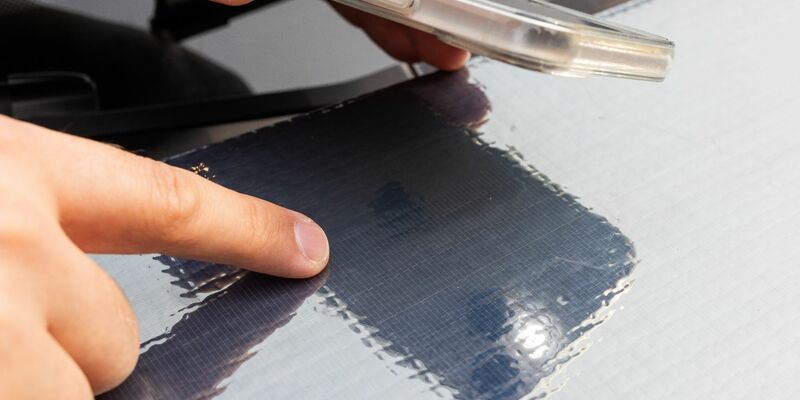 Ein Forscher des Fraunhofer ISE zeigt auf die Struktur der Solarzellen auf einer Motorhaube. - Foto: Philipp von Ditfurth/dpa