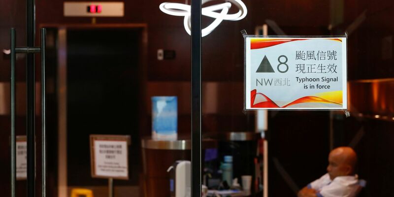 Menschen mit Regenschirmen kämpfen in Hongkong gegen starken Wind und Regen des Taifuns «Saola» an. - Foto: Daniel Ceng/AP/dpa