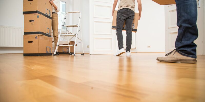 Ein junger Mann, eine ältere Frau und ein älterer Mann tragen Umzugskartons in eine Wohnung. In Deutschland betrug das Durchschnittsalter beim Auszug geschlechterübergreifend 23,8 Jahre. - Foto: Christin Klose/dpa-tmn/dpa