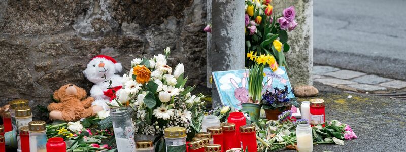 Kerzen und Blumen an einer Mauer vor dem Kinder- und Jugendhilfezentrum in Wunsiedel, in dem die Zehnjährige tot aufgefunden wurde. - Foto: Daniel Vogl/dpa