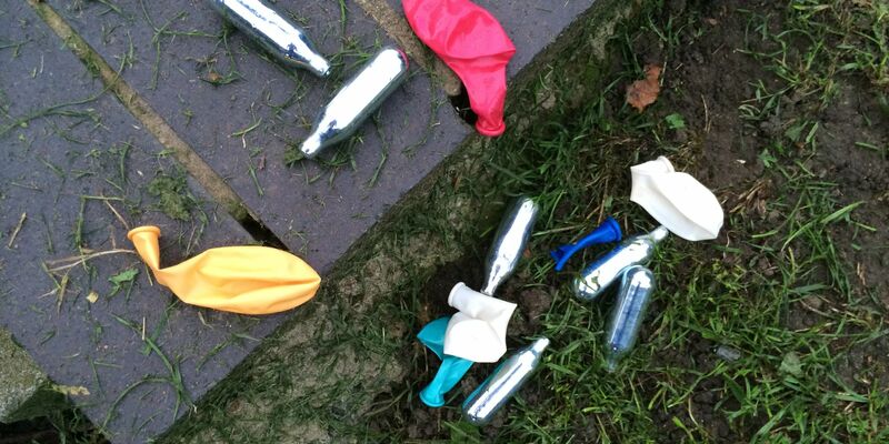 Lachgas-Kartuschen und Luftballons in einem Park in London. Die britische Regierung will den Konsum von Lachgas eindämmen. - Foto: Teresa Dapp/dpa