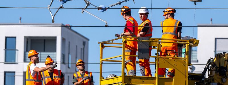 Arbeiter reparieren in München eine abgerissene Oberleitung. - Foto: Lennart Preiss/dpa