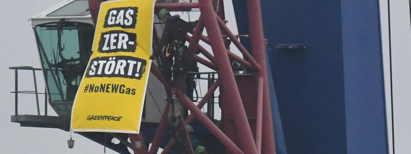 Greenpeace-Aktivisten protestieren auf einem Kran gegen den Start der Verlegung einer Gas-Pipeline im Hafen von Mukran im Norden der Insel Rügen. - Foto: Stefan Sauer/dpa