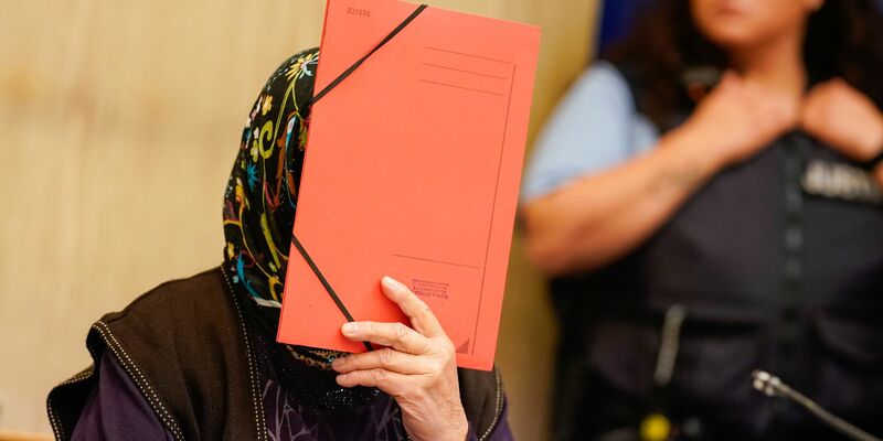 Die Angeklagte verbirgt ihr Gesicht im Verhandlungssaal des Landgerichts Mannheim. - Foto: Uwe Anspach/dpa