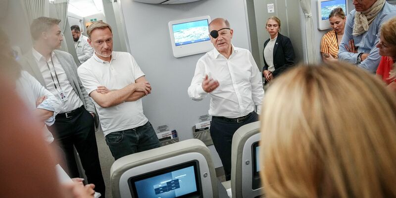 Bundeskanzler Olaf Scholz (r, SPD) und Finanzminister Christian Lindner (FDP) sprechen auf dem Flug nach Neu Dehli mit Journalisten. - Foto: Kay Nietfeld/dpa