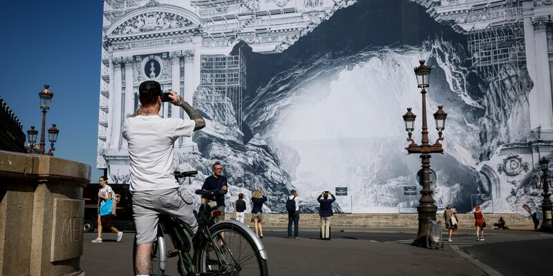 Ein Fahrradfahrer ist vor der verzierten Opera Garnier in Paris unterwegs. - Foto: Thomas Padilla/AP/dpa