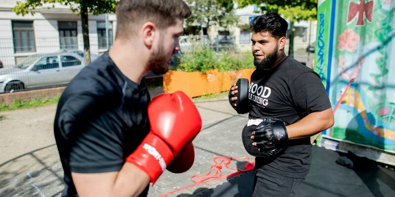 Aytac Alsancak (r.), und Oguzhan Demir, beide Boxtrainer im sogenannten Hood Training, auf dem Quartiersplatz Leher Pausenhof im Stadtteil Lehe. - Foto: Hauke-Christian Dittrich/dpa