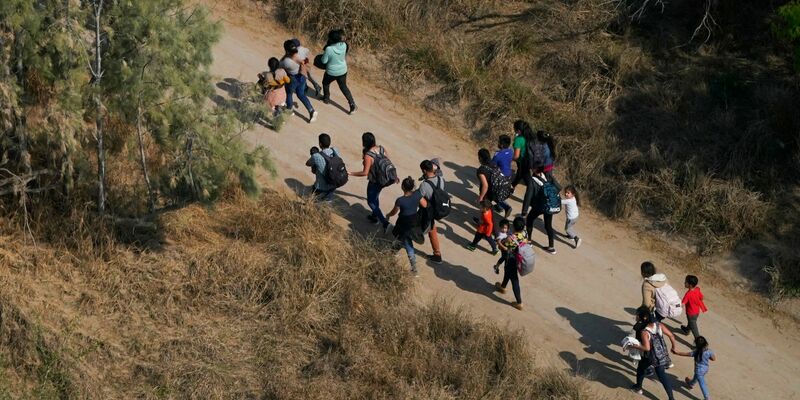 Migranten gehen im Süden von Texas über einen Feldweg, nachdem sie die Grenze zwischen den USA und Mexiko überquert haben. - Foto: Julio Cortez/AP/dpa