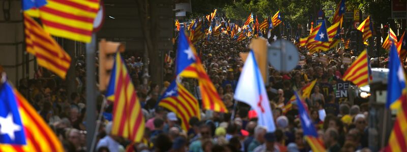 Menschen schwenken in Barcelona Unabhängigkeitsflaggen bei einer Kundgebung für die Abspaltung Kataloniens von Spanien. - Foto: Emilio Morenatti/AP/dpa