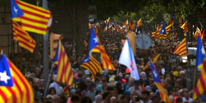 Mit Unabhängigkeitsflaggen fordern Menschen in Barcelona die Abspaltung Kataloniens von Spanien. - Foto: Emilio Morenatti/AP/dpa