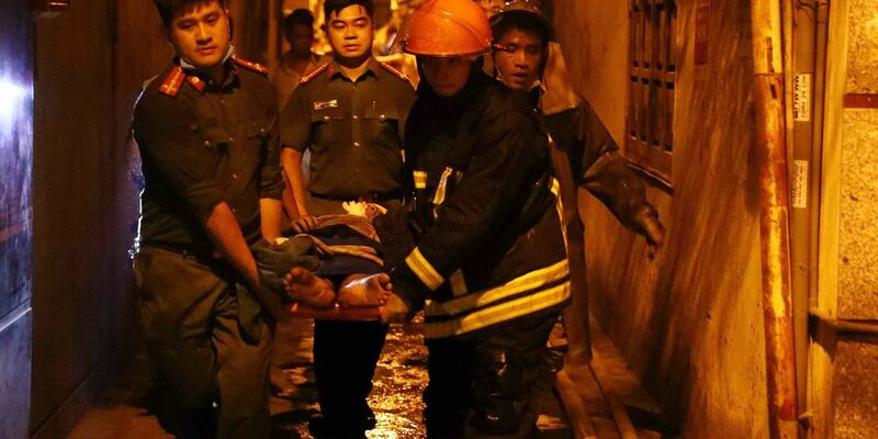 Rettungskräfte tragen eine Person aus einem brennenden Gebäude in der vietnamesischen Hauptstadt Hanoi. - Foto: Pham Trung Kien/VNA/AP/dpa