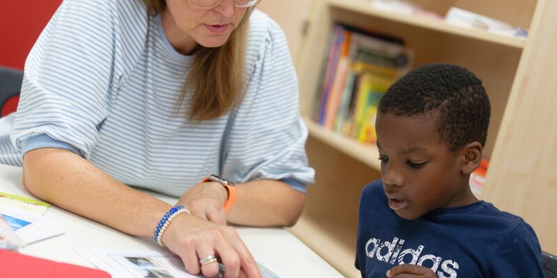 Lernhelferin Sabine Güllich unterstützt Schüler Hassan in einem Leseraum einer Grundschule in Hürth. - Foto: Henning Kaiser/dpa