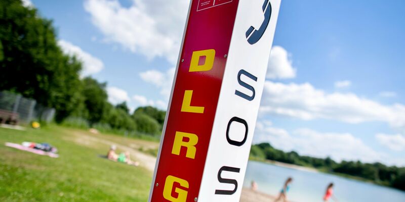 Eine Notrufsäule der DLRG am Rande eines Badesees. - Foto: Hauke-Christian Dittrich/dpa
