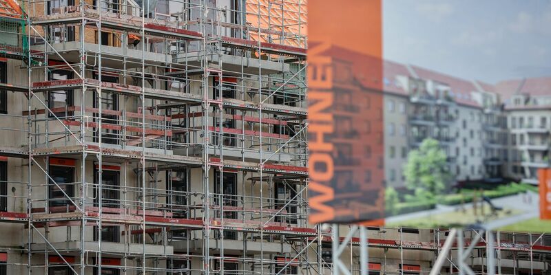 Eine Bautafel steht vor der Baustelle mehrerer Miethäuser in Leipzig. Der Städtetag fordert mehr Wohnungsbau. - Foto: Jan Woitas/dpa