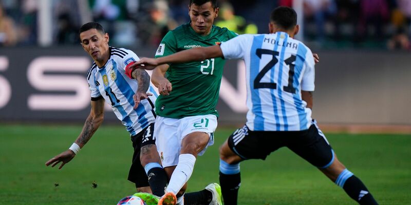 Boliviens Hector Cuellar in Aktion gegen die Argentinier Angel Di Maria (l) und Nahuel Molina (21). - Foto: Juan Karita/AP