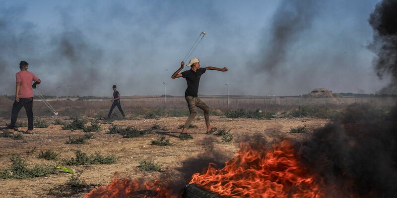 Ein palästinensischer Jugendlicher schleudert in Richtung israelischer Truppen. - Foto: Saher Alghorra/ZUMA Press Wire/dpa
