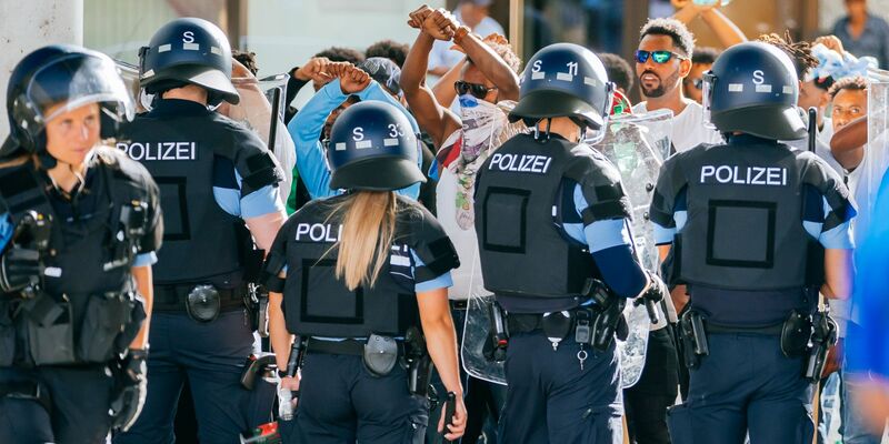 Eine Gruppe von Menschen wird nach Ausschreitungen bei einer Eritrea-Veranstaltung von Polizeikräften eingekesselt. - Foto: Thomas Niedermueller/dpa