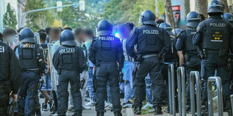 Eine Gruppe von Menschen wird nach Ausschreitungen bei einer Eritrea-Veranstaltung von Polizeikräften eingekesselt. - Foto: Jason Tschepljakow/dpa