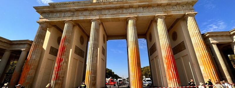 Mitglieder der Klimaschutzgruppe Letzte Generation haben das Brandenburger Tor in Berlin mit oranger Farbe angesprüht. - Foto: Paul Zinken/dpa