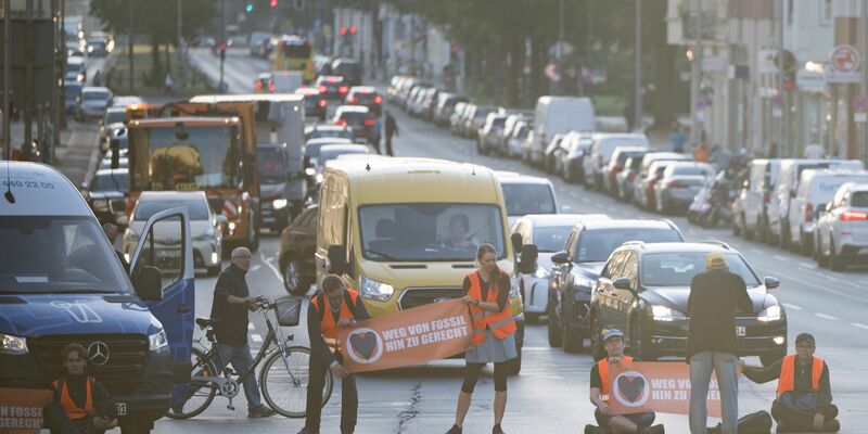 Statt sich auf die Straße zu setzen oder festzukleben, hielten Demonstrantinnen und Demonstranten heute ogenannte Laufblockaden ab und gingen mit Bannern vor dem Verkehr her. - Foto: Sebastian Christoph Gollnow/dpa