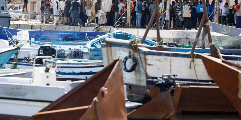 Migranten stehen an einem Hafen auf Lampedusa. - Foto: Cecilia Fabiano/LaPresse via ZUMA Press/dpa