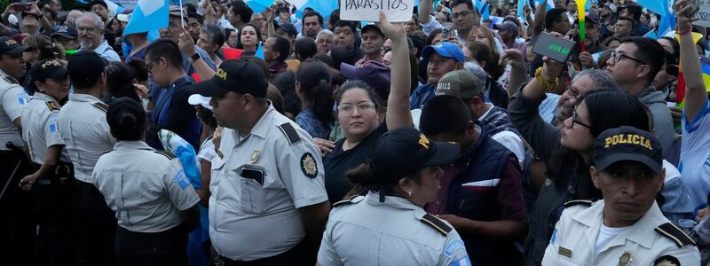 Während einer Demonstration in Guatemala-Stadt hält eine Frau ein Schild mit der Aufschrift «Parasiten raus» in die Höhe. Tausende Menschen protestieren in dem lateinamerikanischen Land gegen die Generalstaatsanwaltschaft. - Foto: Moises Castillo/AP/dpa