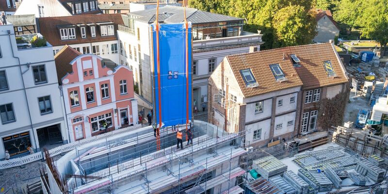 Ein tonnenschweres Scheibenteil wird von einem Kran in das im Umbau befindlche Meeresmuseum manövriert. - Foto: Stefan Sauer/dpa
