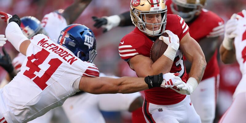 San Francisco 49ers Running Back Christian McCaffrey (r) läuft gegen New York Giants Linebacker Micah McFadden (41). - Foto: Jed Jacobsohn/AP/dpa