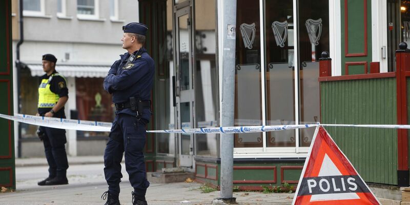 Polizisten stehen vor der Kneipe in Sandviken, in der zwei Menschen starben und zwei weitere verletzt wurden. - Foto: Henrik Hansson/TT News Agency/AP/dpa