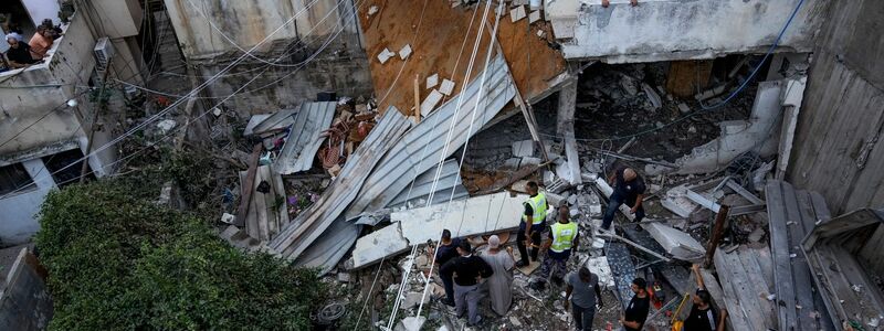 Palästinenser inspizieren nach dem Einsatz der israelischen Armee ein beschädigtes Gebäude. - Foto: Majdi Mohammed/AP