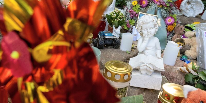 Neben einem Fußballfeld an einem See in Pragsdorf, dem möglichen Tatort, sind Kerzen, Plüschtiere und Fotos abgelegt. - Foto: Stefan Sauer/dpa