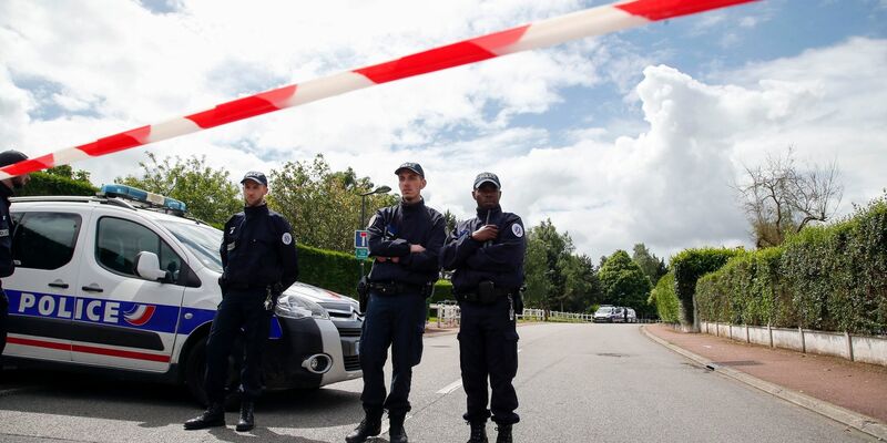 Beamte stehen 2016 am Tatort in Magnanville bei Paris. - Foto: Thibault Camus/AP/dpa