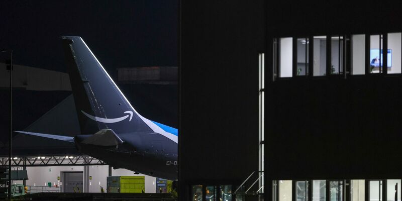 Ein Frachtflugzeug von Amazon steht neben einem Bürogebäude auf dem Flughafen Leipzig-Halle. - Foto: Jan Woitas/dpa