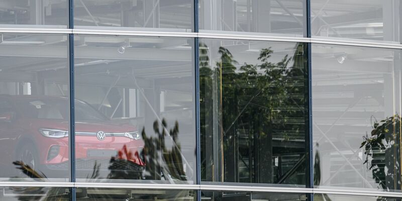 Ein Elektrofahrzeug ID.4 steht im Autoturm der Gläsernen VW-Manufaktur. Auch am Standort Dresden wird die Produktion vorübergehend gedrosselt. - Foto: Robert Michael/dpa/Symbolbild