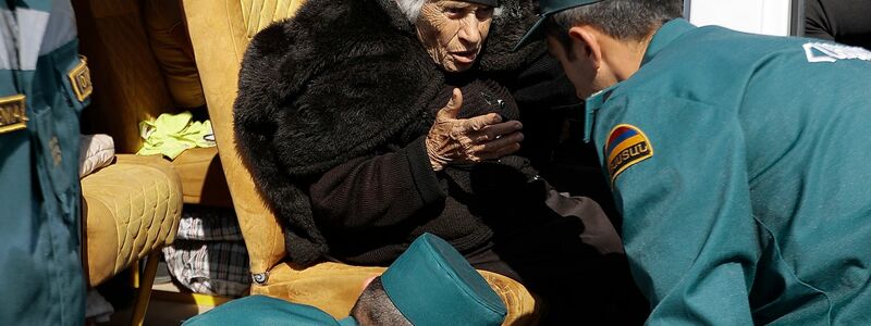 Mitarbeiter des armenischen Ministeriums für Notfallsituationen sprechen mit einer älteren armenischen Frau aus Berg-Karabach bei ihrer Ankunf in Goris. - Foto: Vasily Krestyaninov/AP/dpa
