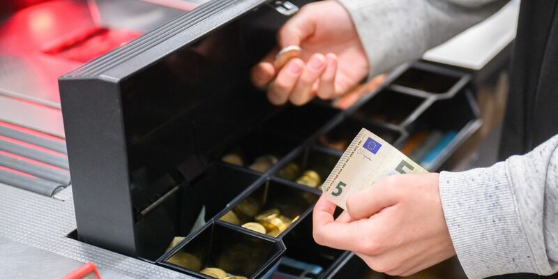 Eine Kassiererin gibt einer Kundin Wechselgeld an der Kasse eines Supermarktes. Die Inflation ist auf dem Rückzug. (Symbolbild) - Foto: Julian Stratenschulte/dpa